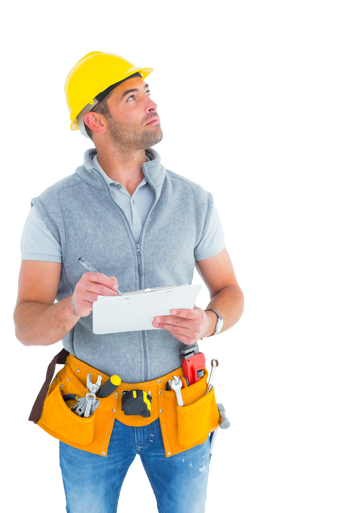 Manual worker looking up while writing on clipboard over white background